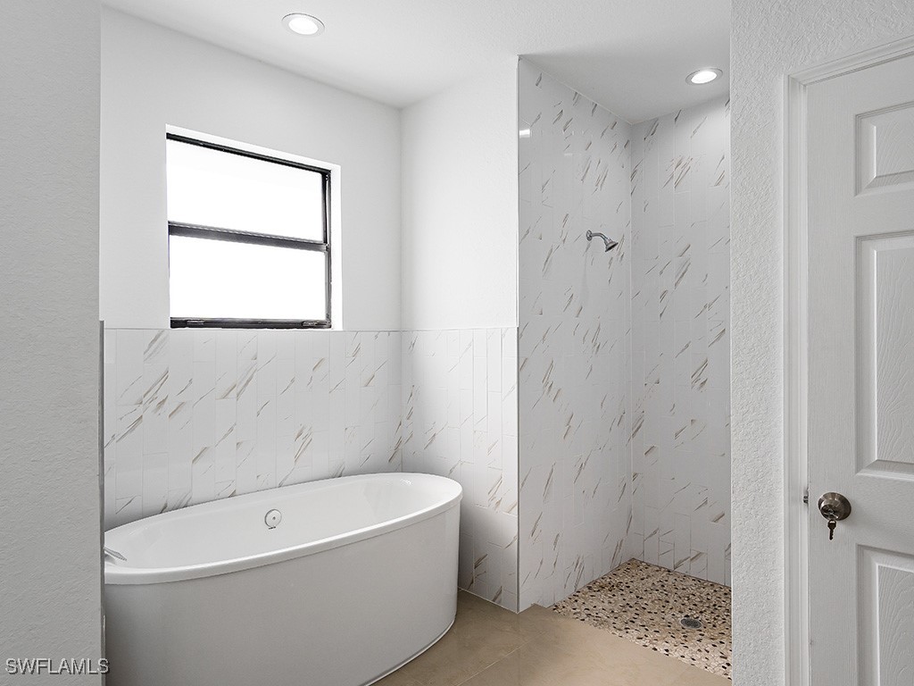 902 Williams Avenue Lehigh Acres, FL 33972 - Photo 15 of 30 a bathroom with a bathtub and shower