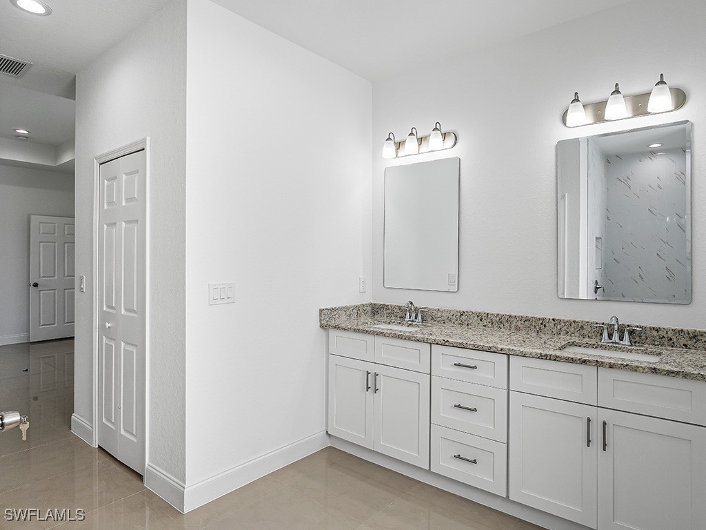 902 Williams Avenue Lehigh Acres, FL 33972 - Photo 16 of 30 a bathroom with a granite countertop sink and a mirror