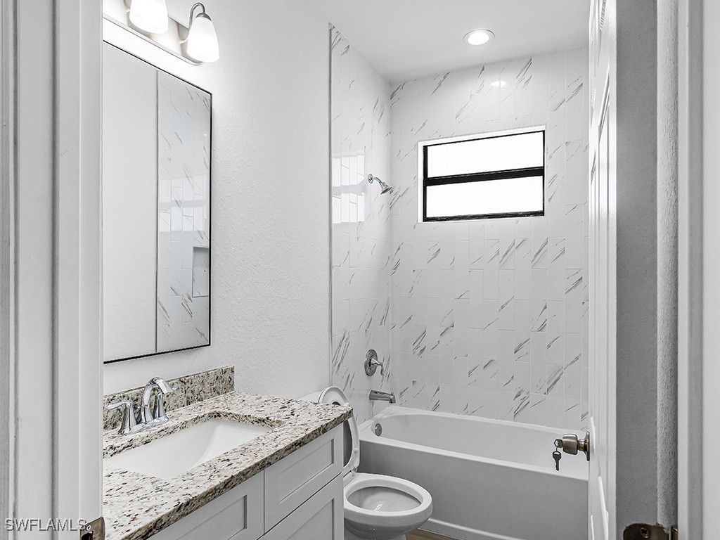 902 Williams Avenue Lehigh Acres, FL 33972 - Photo 18 of 30 a bathroom with a granite countertop sink toilet and shower