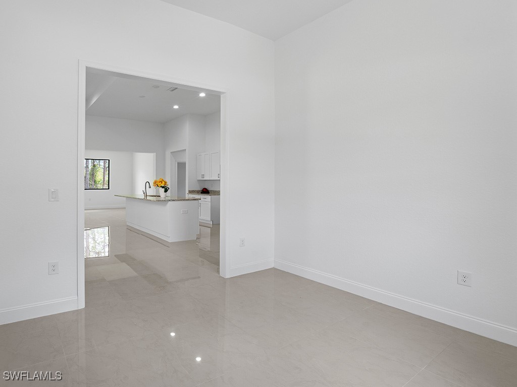 902 Williams Avenue Lehigh Acres, FL 33972 - Photo 26 of 30 an empty room with kitchen and mirror