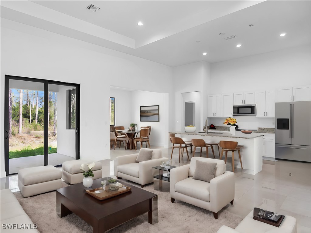 902 Williams Avenue Lehigh Acres, FL 33972 - Photo 7 of 30 a living room with furniture kitchen view and a large window