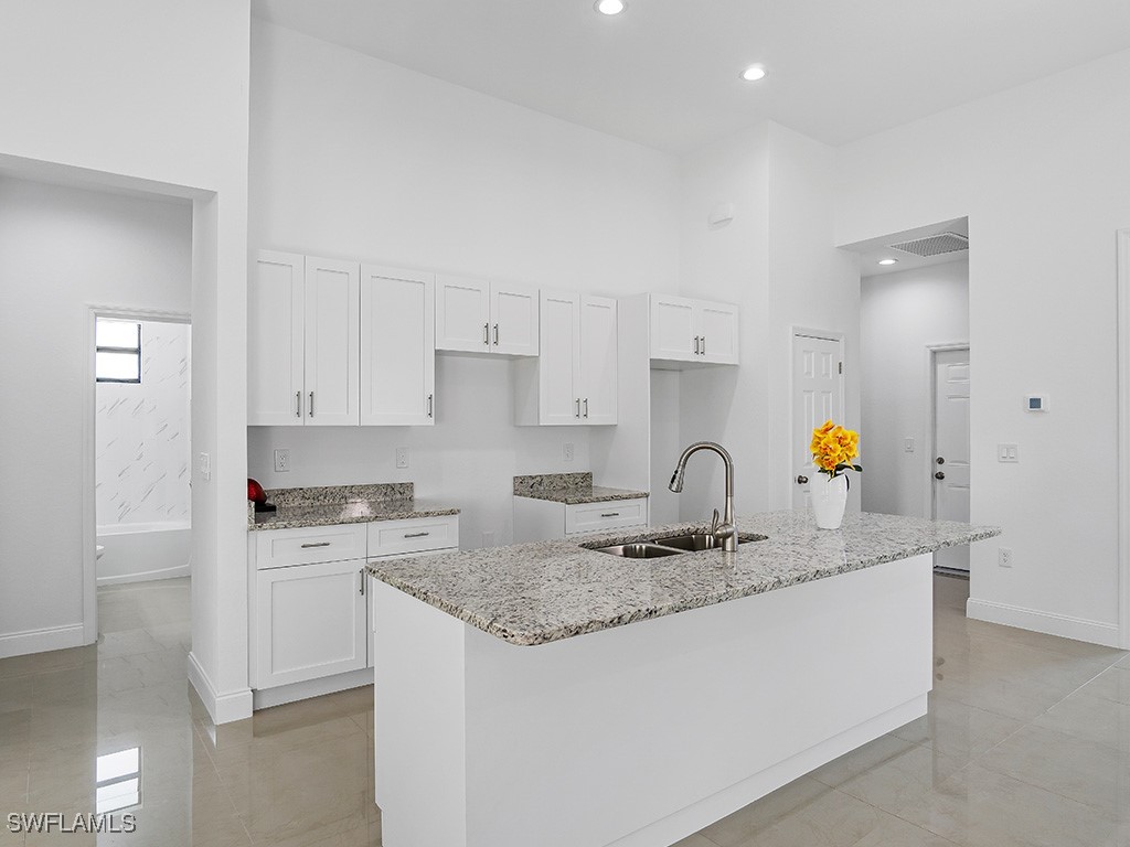 902 Williams Avenue Lehigh Acres, FL 33972 - Photo 9 of 30 a kitchen with granite countertop a sink cabinets and stainless steel appliances