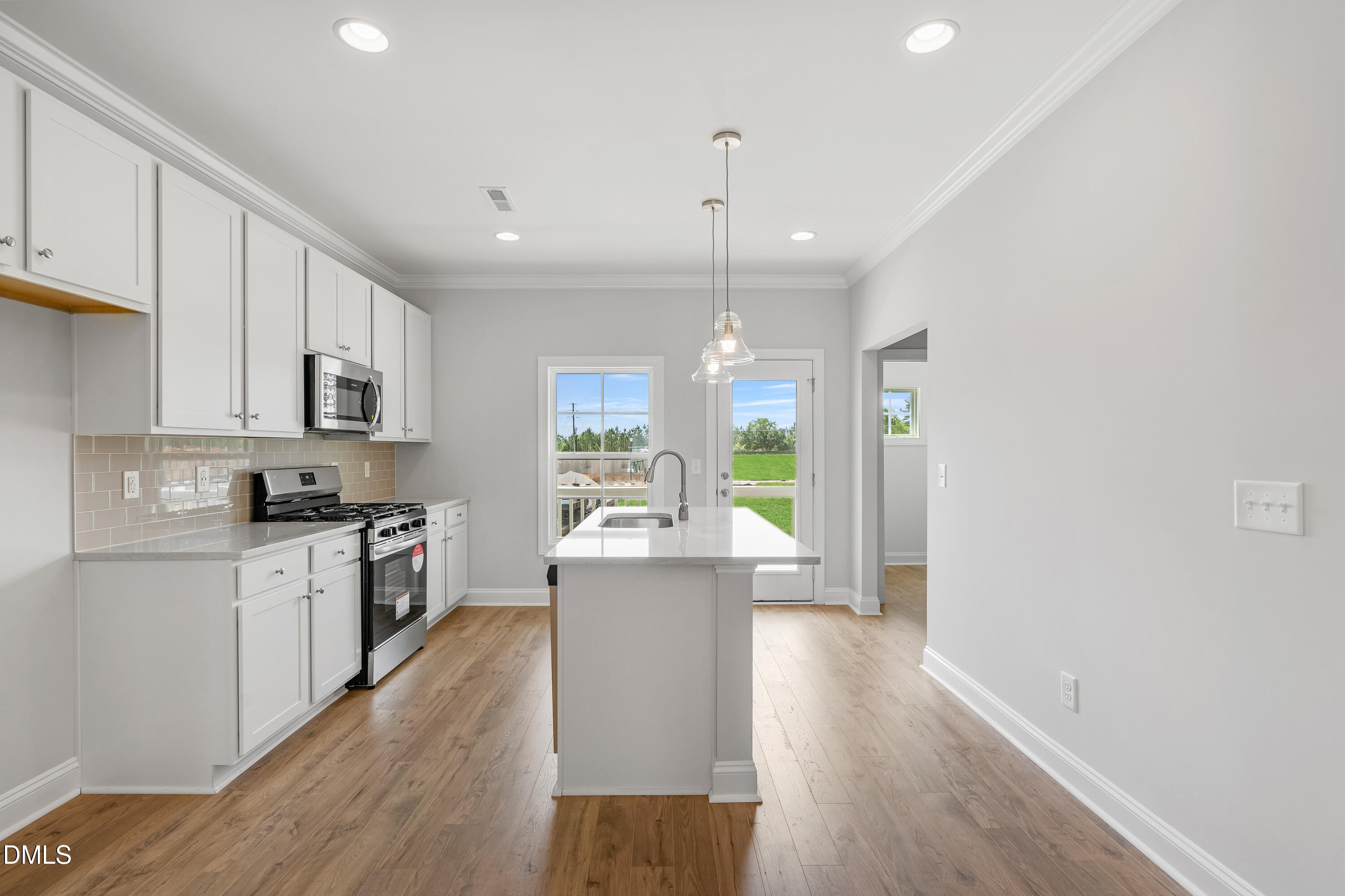 519 Forestville Road Wake Forest, NC 27587 - Photo 19 of 38 a large kitchen with stainless steel appliances granite countertop a stove a sink dishwasher and a refrigerator with wooden floor