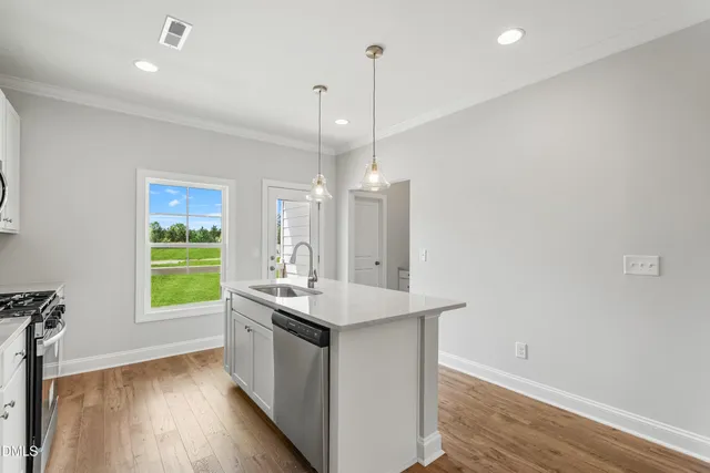 a kitchen with kitchen island a sink appliances and a window