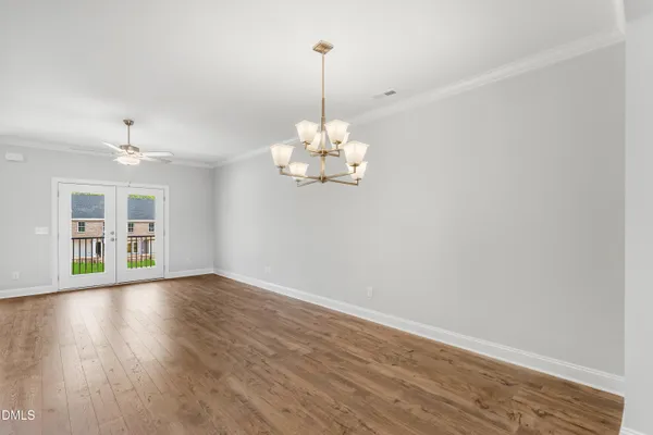 a view of a room with wooden floor chandelier and window