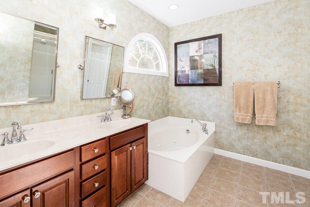 5020 Big Creek Road Raleigh, NC 27613 - Photo 18 of 25 a bathroom with a tub a sink and mirror