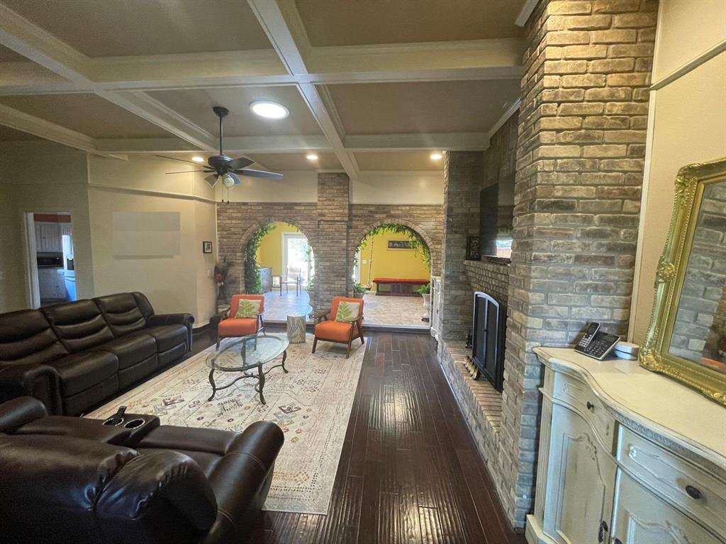 3612 Cross Bend Road Plano, TX 75023 - Photo 9 of 38 Living room featuring ceiling fan, beamed ceiling, a brick fireplace, dark hardwood / wood-style flooring, and coffered ceiling