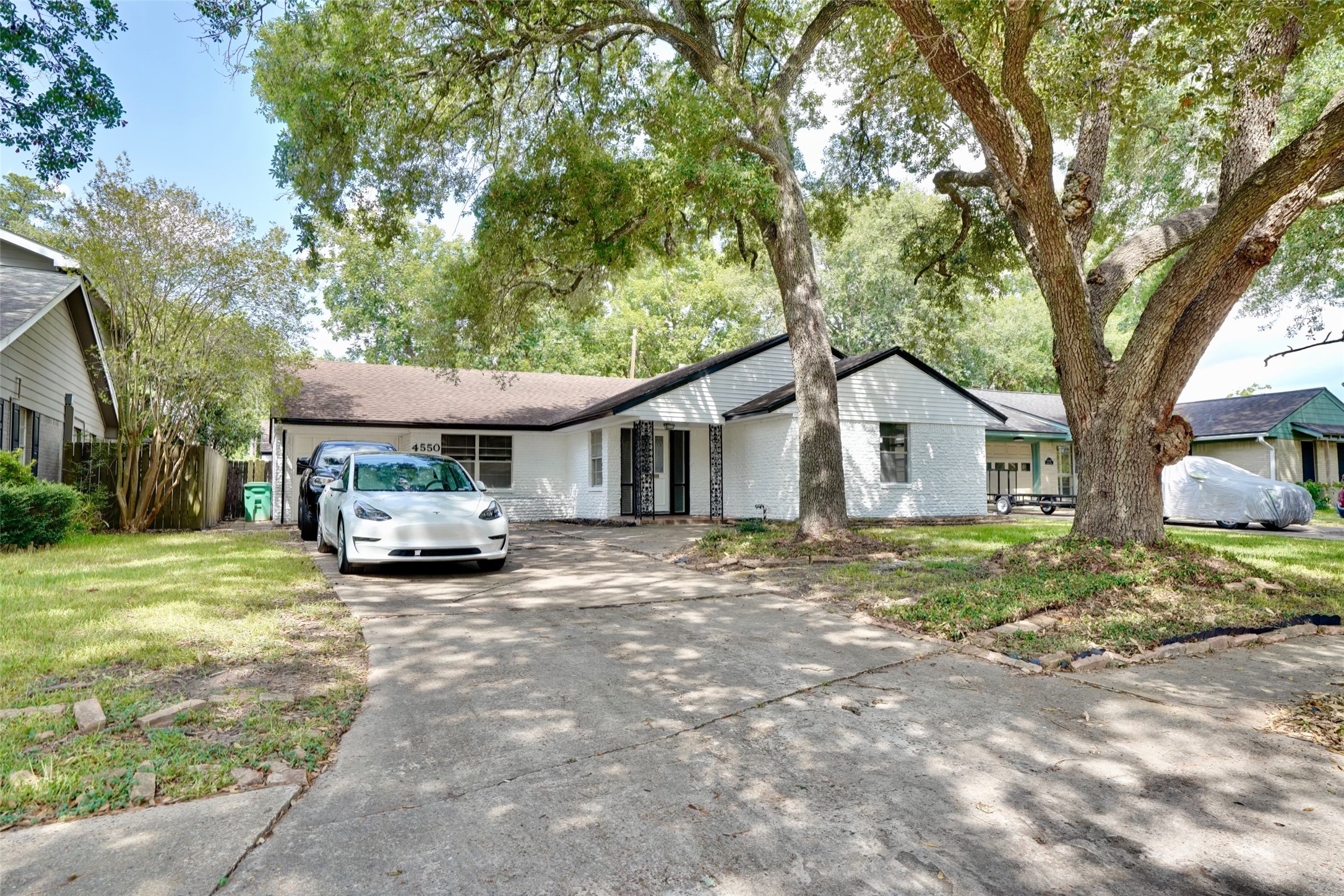 a front view of a house with a yard and trees