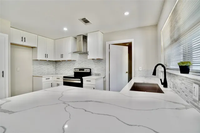 a kitchen with stainless steel appliances granite countertop a stove a refrigerator and a sink