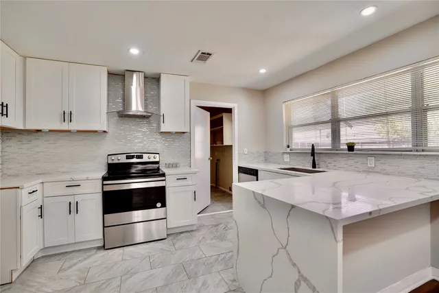 a kitchen with kitchen island white cabinets and refrigerator