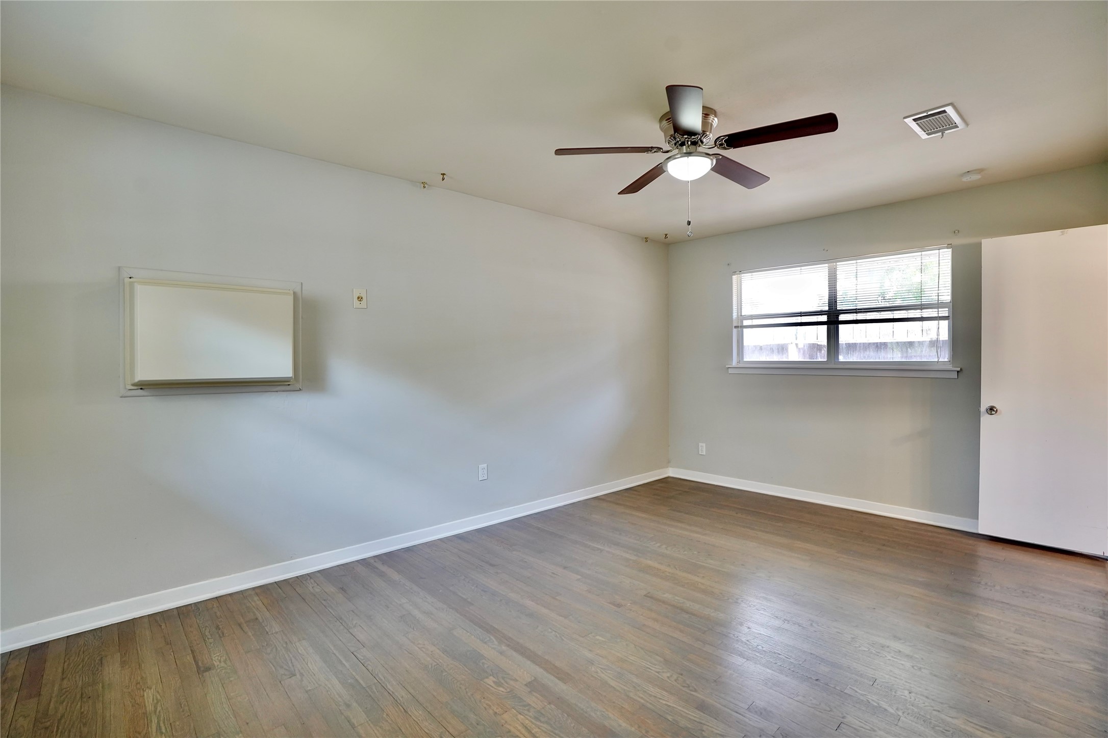 4550 Spellman Road Houston, TX 77035 - Photo 15 of 27 an empty room with wooden floor ceiling fan and windows