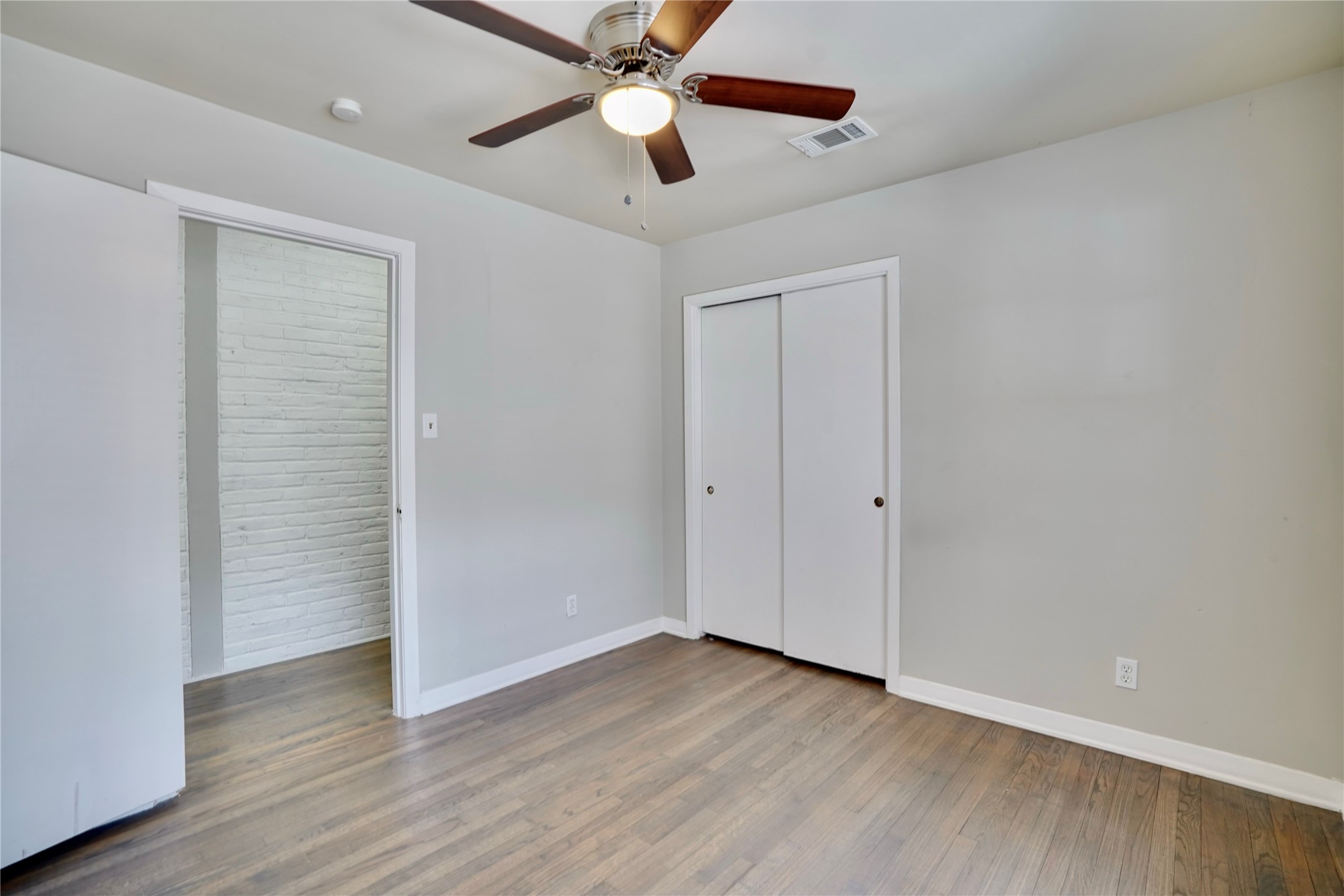 4550 Spellman Road Houston, TX 77035 - Photo 16 of 27 an empty room with wooden floor chandelier fan and closet area