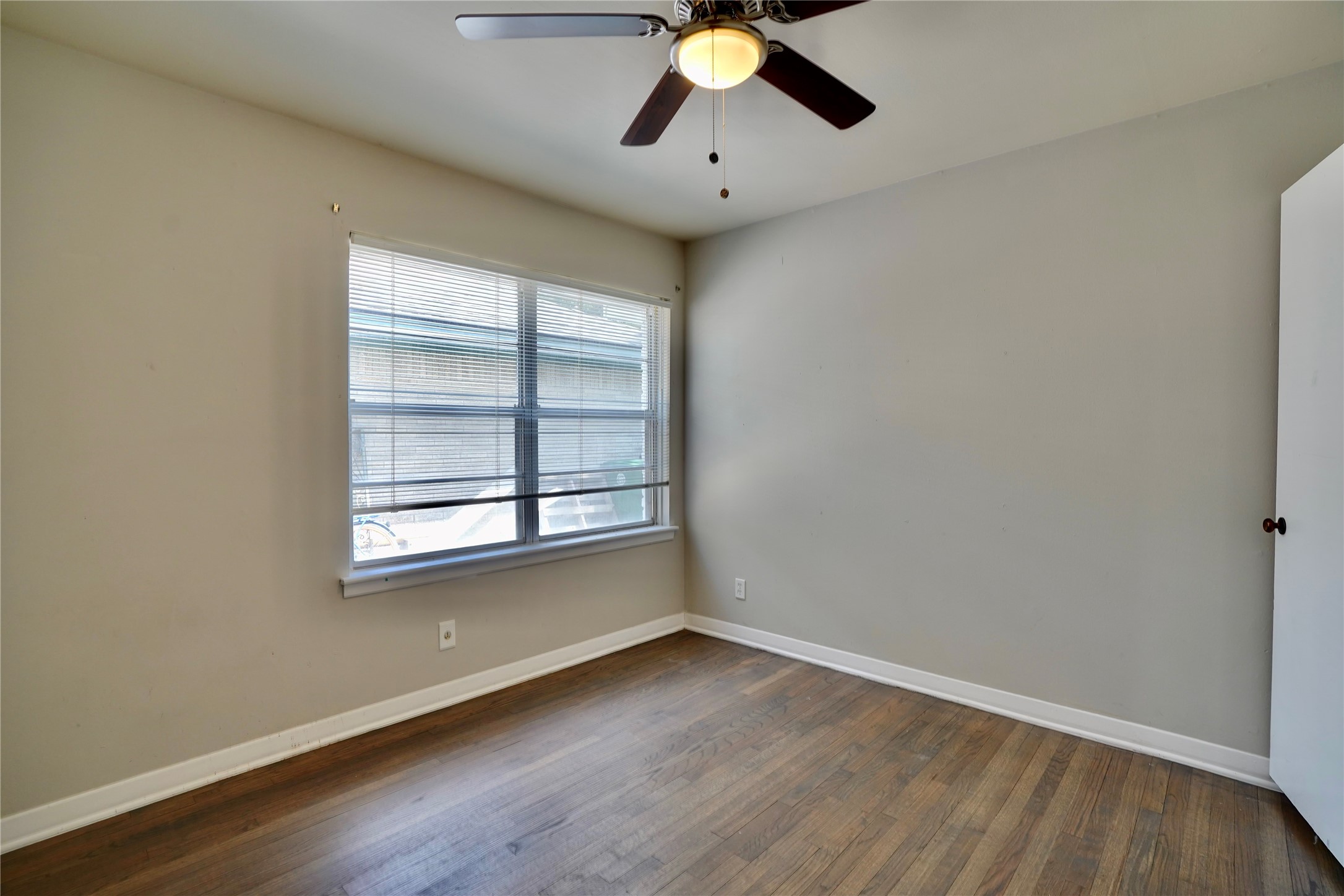 4550 Spellman Road Houston, TX 77035 - Photo 17 of 27 a view of an empty room with wooden floor and a window