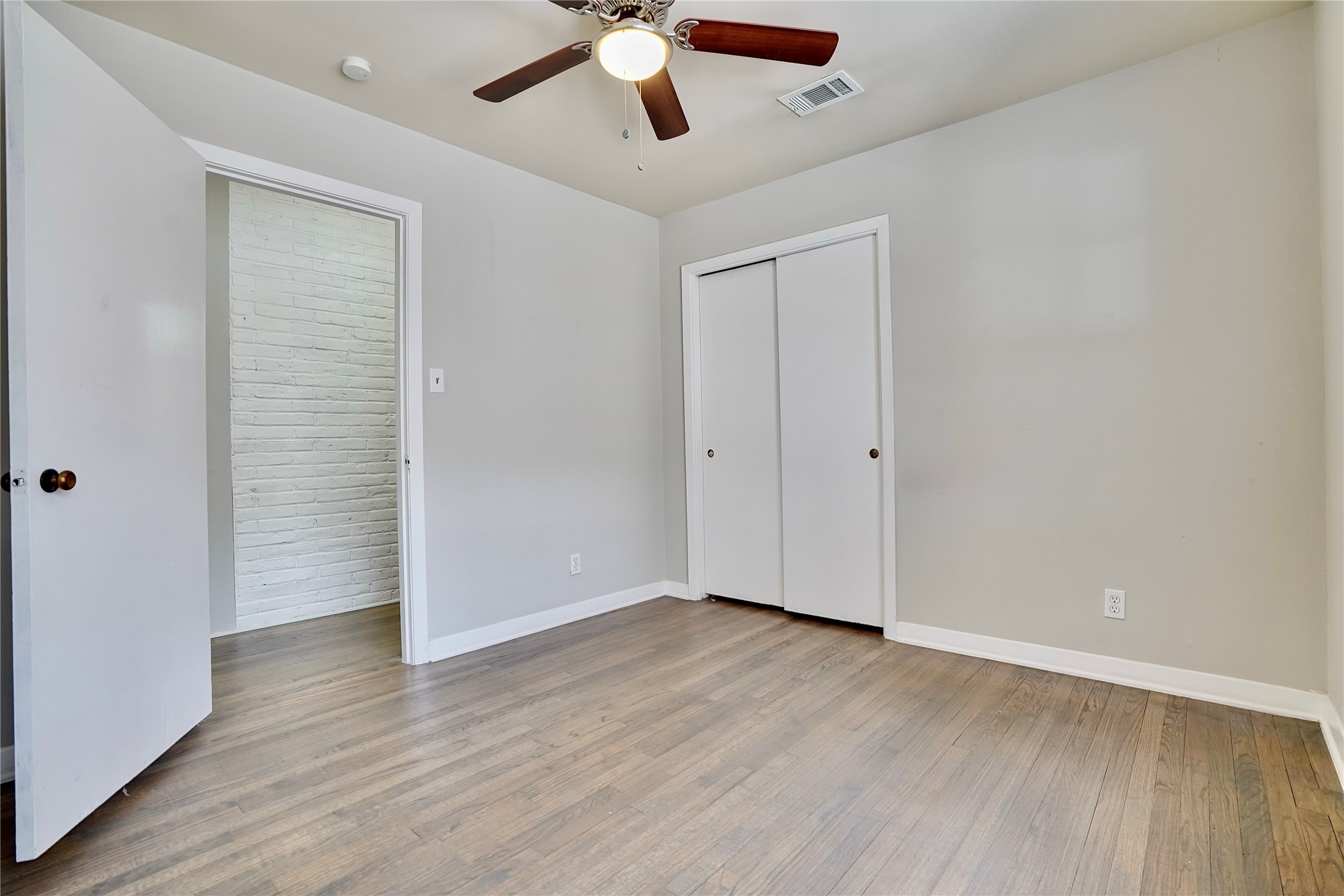 4550 Spellman Road Houston, TX 77035 - Photo 18 of 27 an empty room with wooden floor cabinet and windows