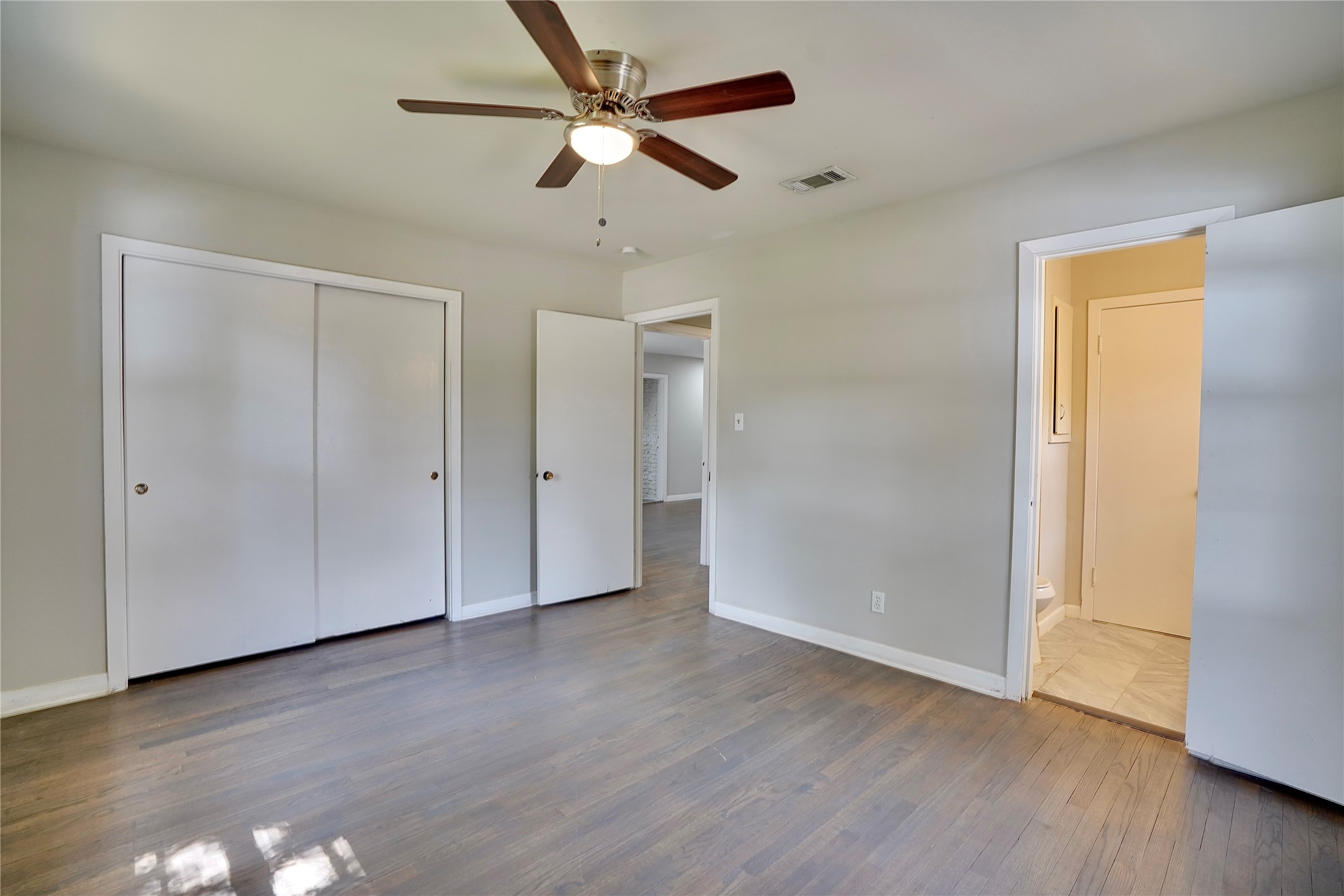 4550 Spellman Road Houston, TX 77035 - Photo 25 of 27 an empty room with wooden floor ceiling fan and windows