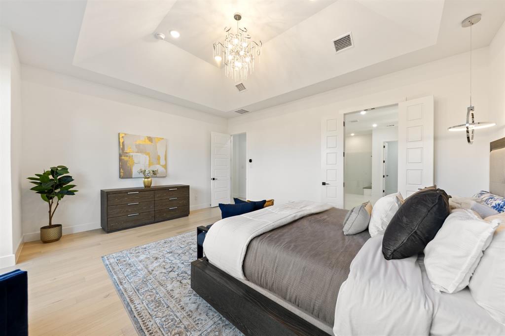 270 Peach Pt Road Prosper, TX 75078 - Photo 20 of 40 a bedroom with a large bed and a chandelier