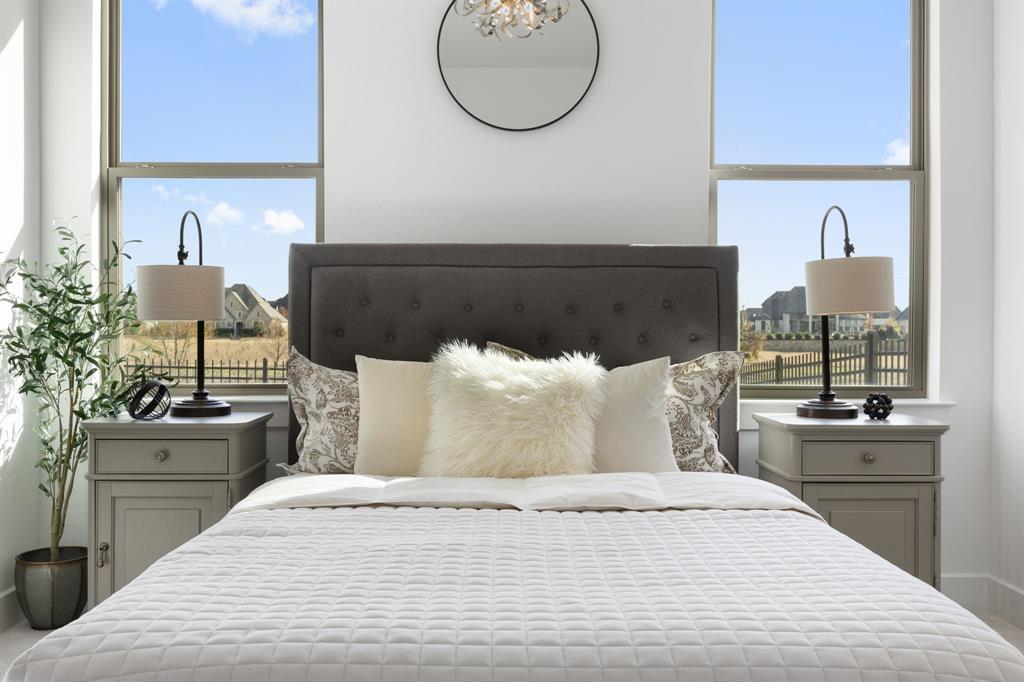 270 Peach Pt Road Prosper, TX 75078 - Photo 24 of 40 a bedroom with a bed and a chandelier