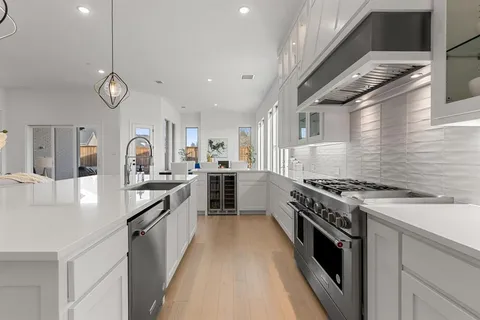 a kitchen with stainless steel appliances granite countertop a stove a sink dishwasher and a refrigerator