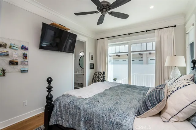 a bedroom with a bed window and a flat screen tv