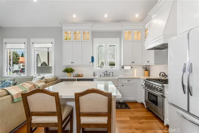 a large kitchen with kitchen island white cabinets and stainless steel appliances