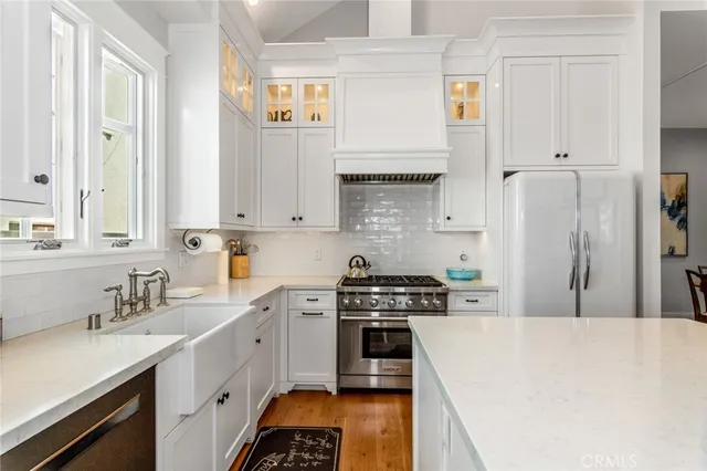 a kitchen with stainless steel appliances a stove a sink a refrigerator and cabinets