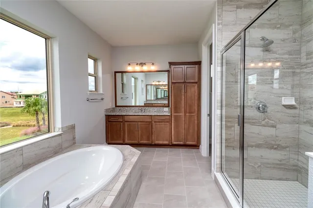 a bathroom with a granite countertop bathtub sink and mirror