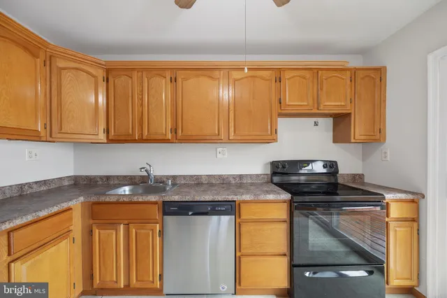a kitchen with stainless steel appliances granite countertop a sink stove and cabinets