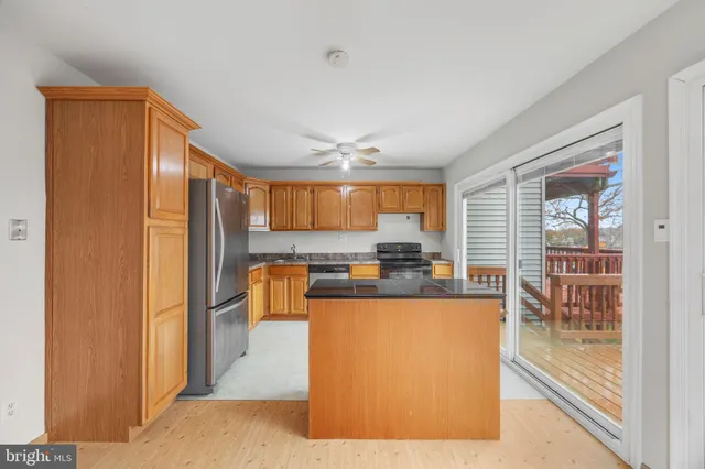 a kitchen with stainless steel appliances granite countertop a refrigerator and a stove top oven