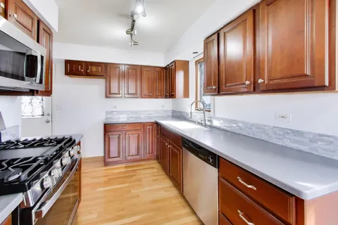 a kitchen with stainless steel appliances granite countertop a sink stove and cabinets