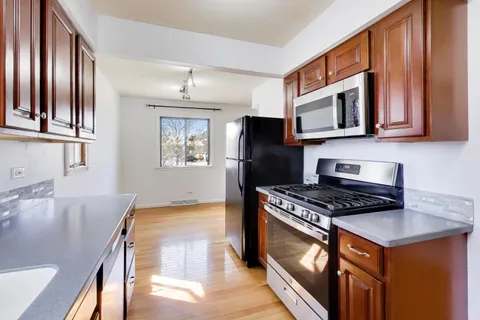 a kitchen with stainless steel appliances granite countertop a stove a sink and a microwave