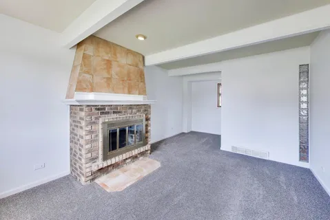 a view of an empty room with a fireplace and a window