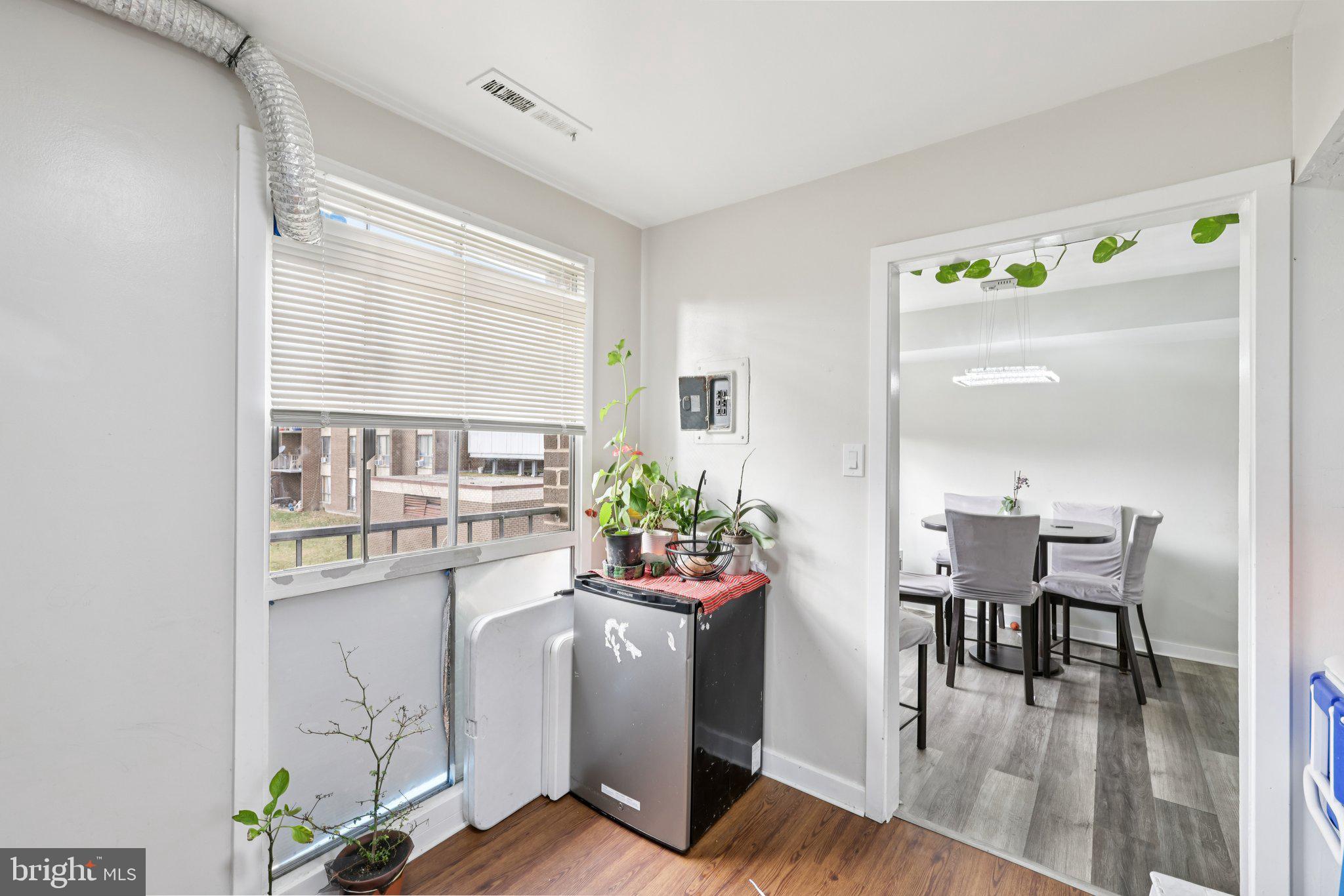 7969 Riggs Road, Unit 9 Hyattsville, MD 20783 - Photo 8 of 30 a dining room with furniture potted plants and wooden floor