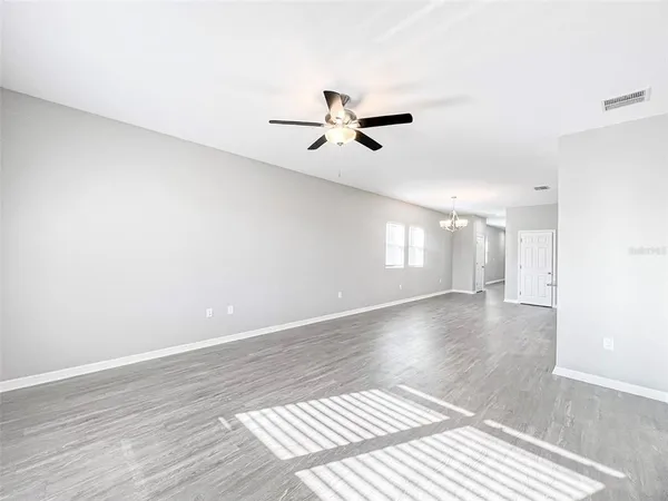 a view of a room with a ceiling fan and window