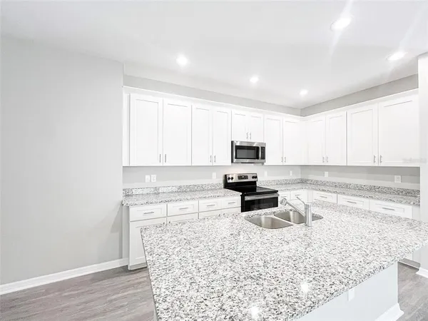 a kitchen with a stove a sink and a microwave