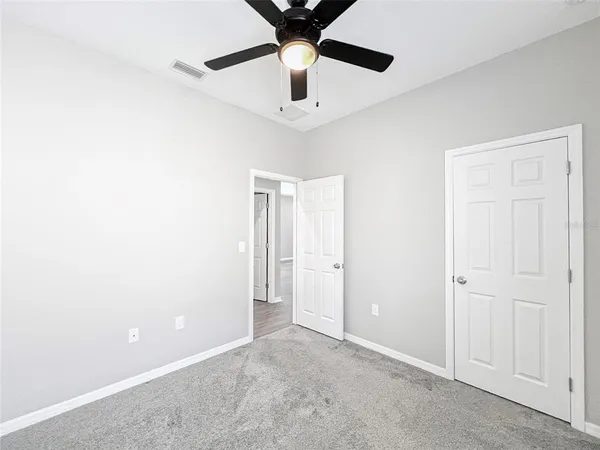 an empty room with window and ceiling fan