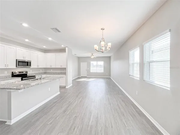 a view of a kitchen with granite countertop stainless steel appliances and a window