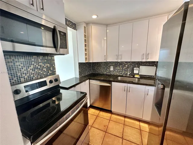 a kitchen with stainless steel appliances wooden cabinets stove and a window