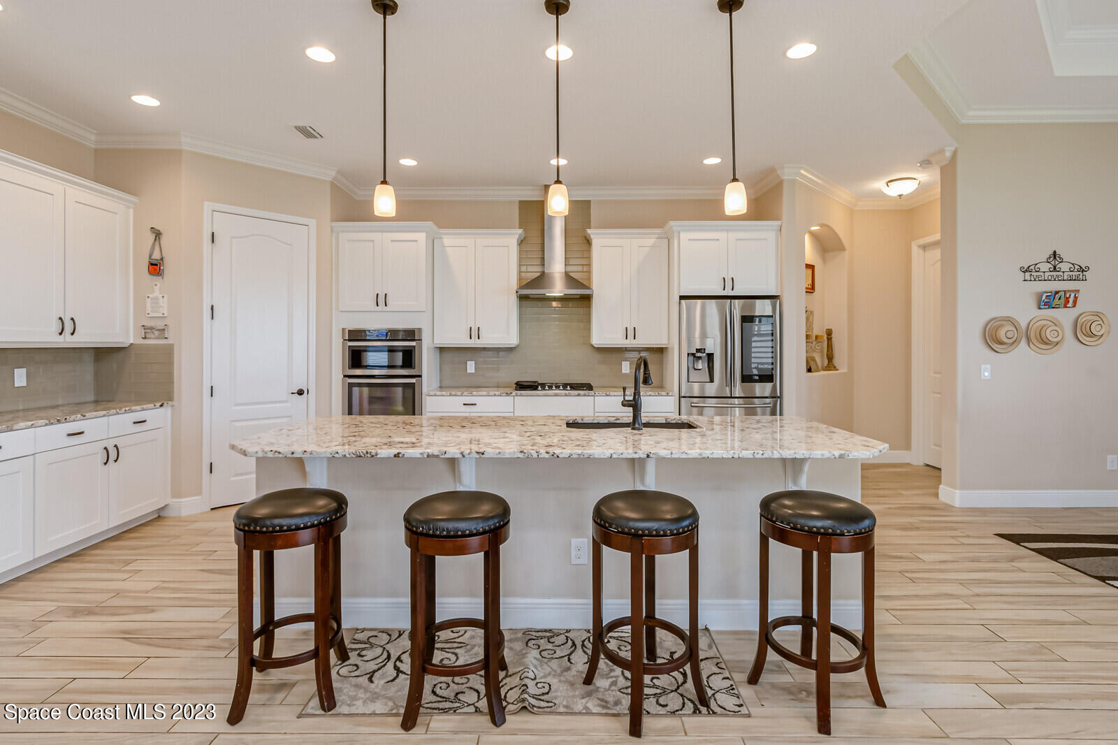 2928 Addison Drive Melbourne, FL 32940 - Photo 17 of 69 a kitchen with stainless steel appliances granite countertop a kitchen island a stove a sink a oven a dining table and chairs