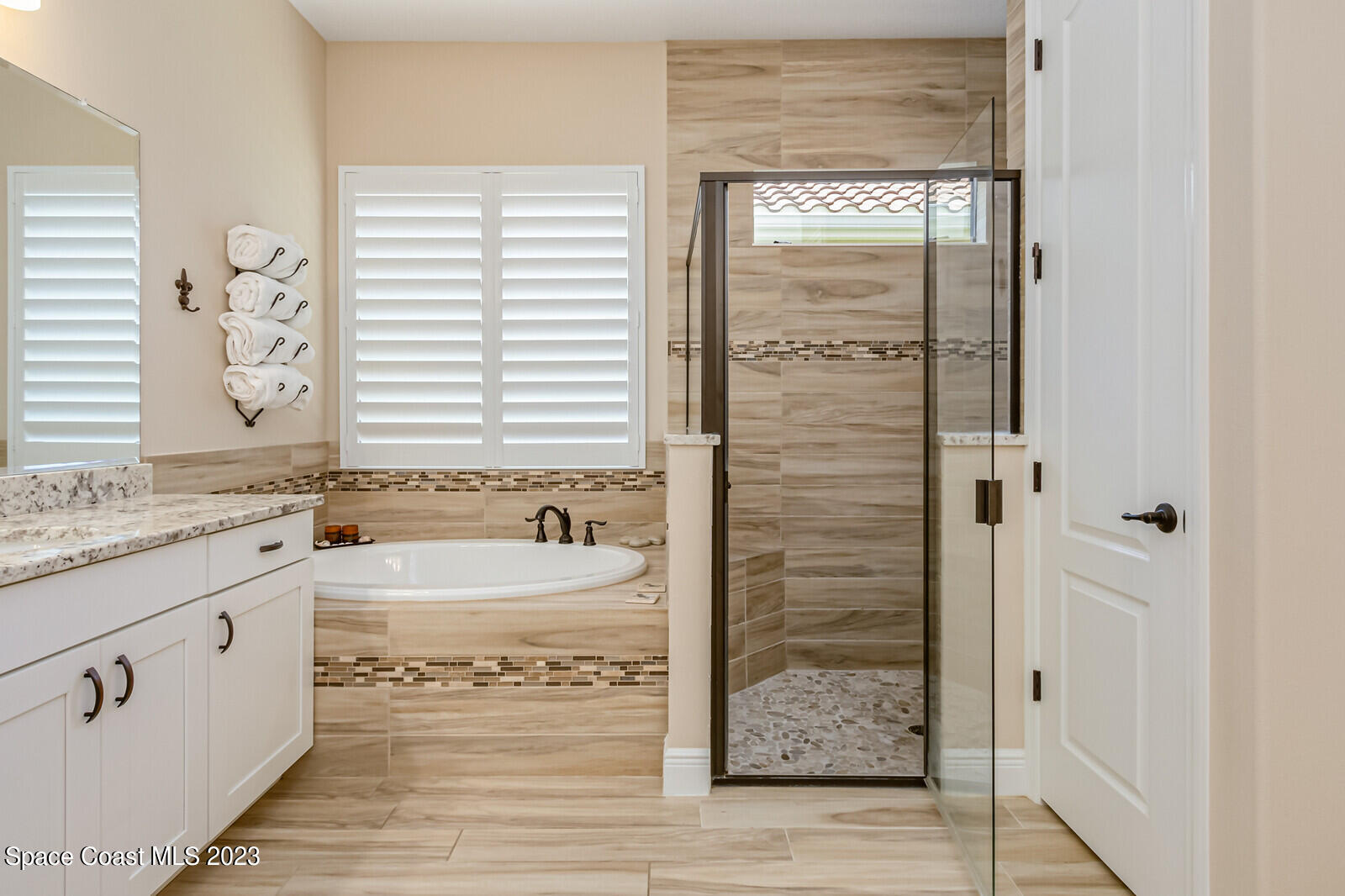 2928 Addison Drive Melbourne, FL 32940 - Photo 28 of 69 a bathroom with a granite countertop sink a bathtub and next to a window