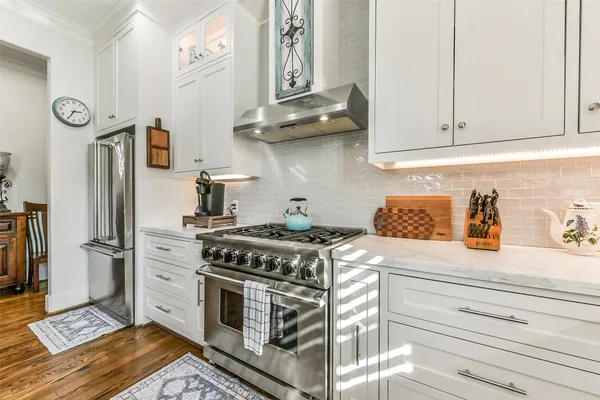 a kitchen with stainless steel appliances granite countertop a lot of cabinets