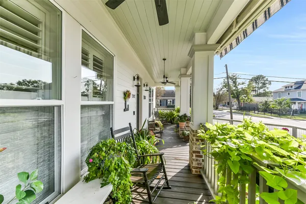 a large kitchen with stainless steel appliances a stove a sink a refrigerator and a dining table with wooden floor