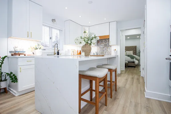 a kitchen with a sink stove cabinets and wooden floor