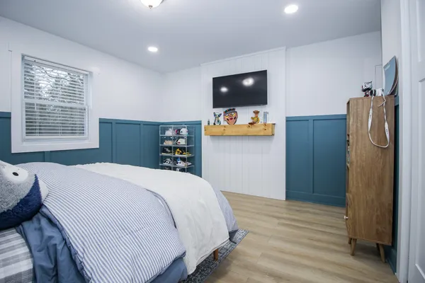 a bedroom with a bed and a painting on the wall