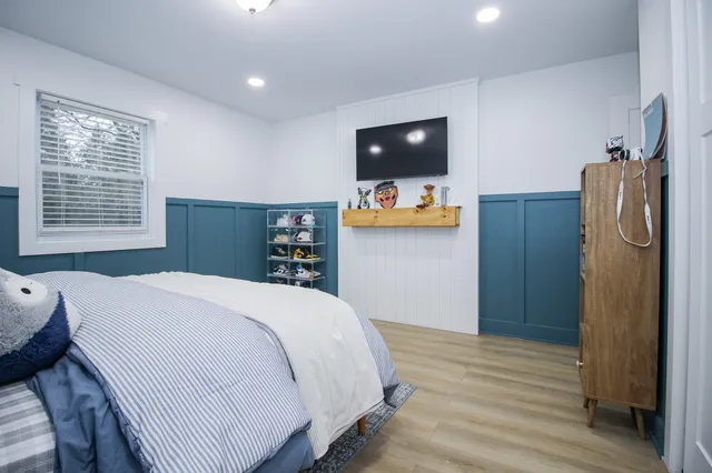 a bedroom with a bed and a painting on the wall