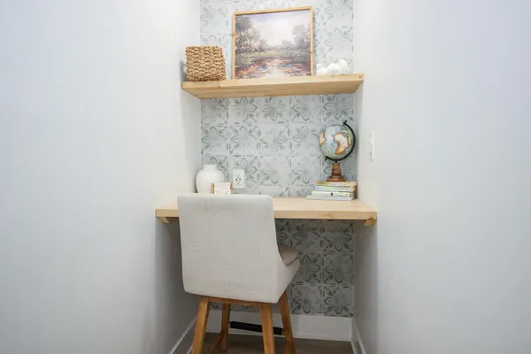 a picture of a room with a bench and potted plant