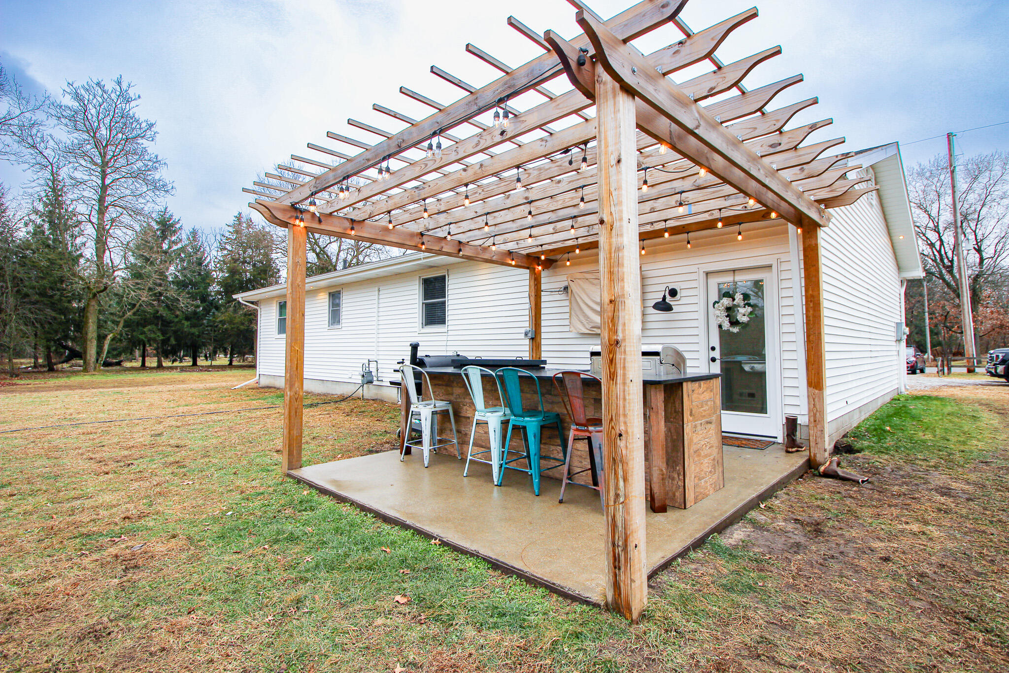 10791 North 1000 West Demotte, IN 46310 - Photo 49 of 55 a view of a patio with a table and chairs under an umbrella with large tree