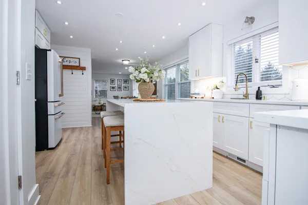 a view of kitchen with sink and refrigerator