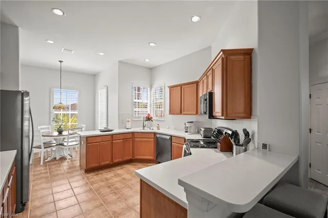 a kitchen with stainless steel appliances granite countertop a sink a stove counter space and cabinets