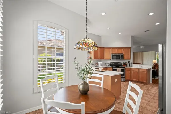 a kitchen with sink refrigerator dining table and chairs