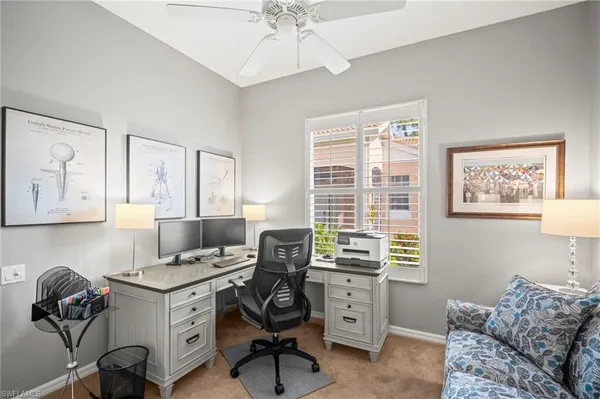 a view of a workspace with furniture and a window